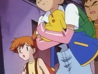 Ash llevando en brazos a Pikachu enfermo al Centro Pokémon.
