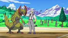 Drayden/Lirio junto a su Haxorus.